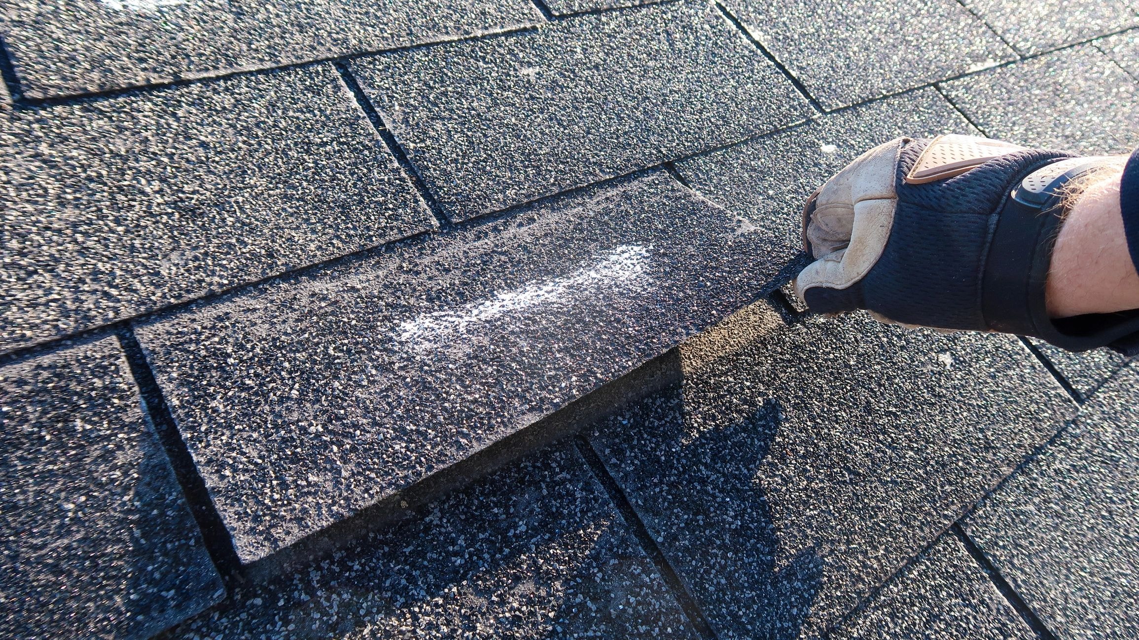 Wind and storm damage with missing shingles on a residential roof